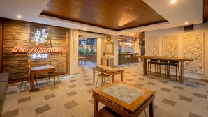 Interior de restaurante con suelo de madera, un letrero de neón y una mezcla de decoración moderna y tradicional.