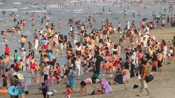 A crowded beach with people engaging in various activities. - Thanh Nam Hotel (Cua Lo)