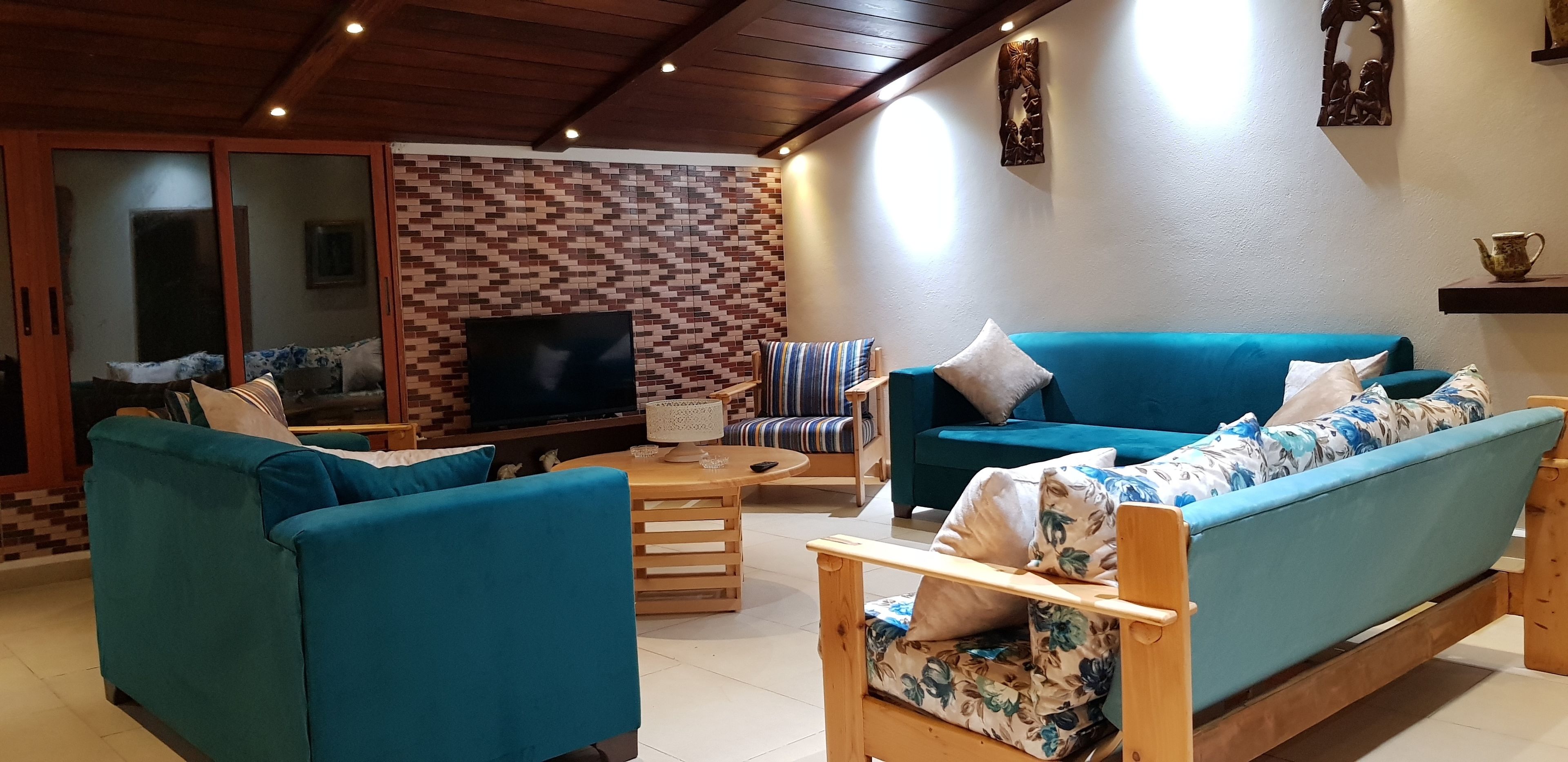 Una sala de estar acogedora con sofás color aguamarina, una mesa de centro de madera y un televisor.