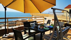 An outdoor dining area with a table, chairs, and a yellow umbrella. - Apartment near Lady of the Sea & Phoenician Wall (Batroun)