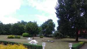 Ein Garten mit ordentlich geschnittenen Hecken, einem Kiesweg und einigen Gartenmöbeln.
