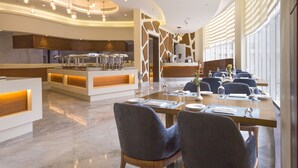 Un comedor moderno con una larga mesa dispuesta para una comida, rodeada de sillas.