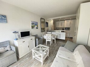 A modern living room with a sofa, a glass coffee table, and a television. - Beautiful 2 rooms Moulleau center with parking (ARCACHON)