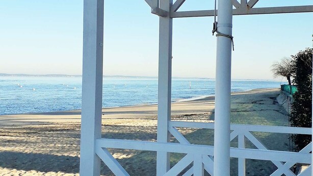 A beach view from a white wooden structure with a clear sky. - Beautiful 2 rooms Moulleau center with parking (ARCACHON)