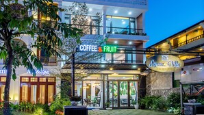 Un edificio moderno con un cartel que dice "SQUARE VILLA" y una tienda de café y productos de frutas.
