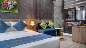 Una habitación de hotel con cama, escritorio, una mesita y un armario.