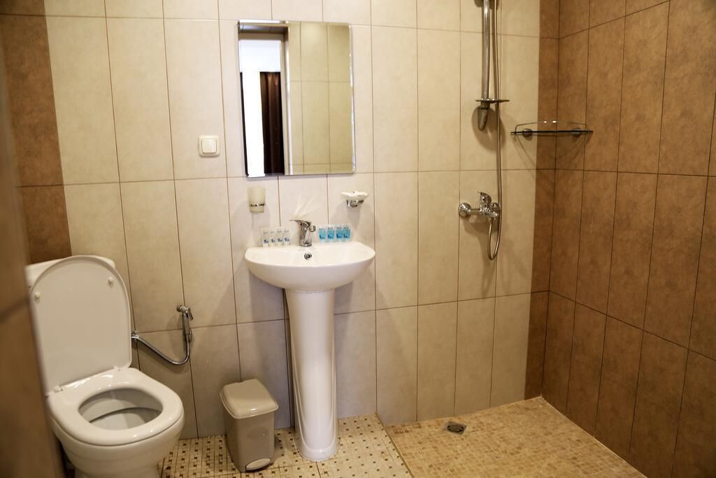 A bathroom with a toilet, sink, and shower.