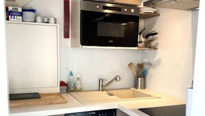 A modern kitchen with a Bosch dishwasher, a microwave, and a stainless steel range hood.
