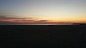 Uma praia com céu claro e mar calmo.