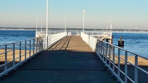 Une jetée qui s’avance dans l’eau, sous un ciel dégagé.