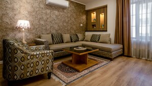 Una sala de estar con un sofá modular, un sillón estampado y una mesa de centro.