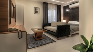 Una habitación de hotel moderna con sofá, una mesita, cama y una planta.
