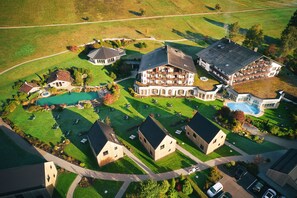 An aerial view of a large estate with multiple buildings, a swimming pool, and well-maintained lawns.