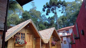 A narrow alley with wooden buildings featuring pitched roofs and flower boxes. - Recanto das Acacias (Camanducaia)