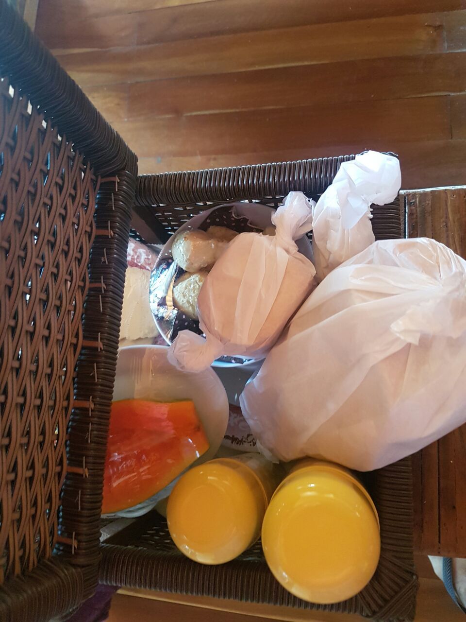 A wicker basket containing various food items, including bread, cheese, and a bottle.
