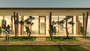 Un bâtiment moderne doté d’une entrée abritée, de grandes fenêtres et d’une pelouse bien entretenue agrémentée de plantes en pot.