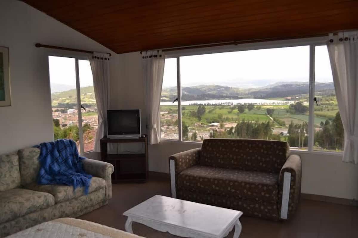 Ein Wohnzimmer mit einer Couch, einem Couchtisch und einem Fernseher.