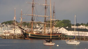 Un grand voilier était amarré dans un port, avec des bâtiments en arrière-plan.
