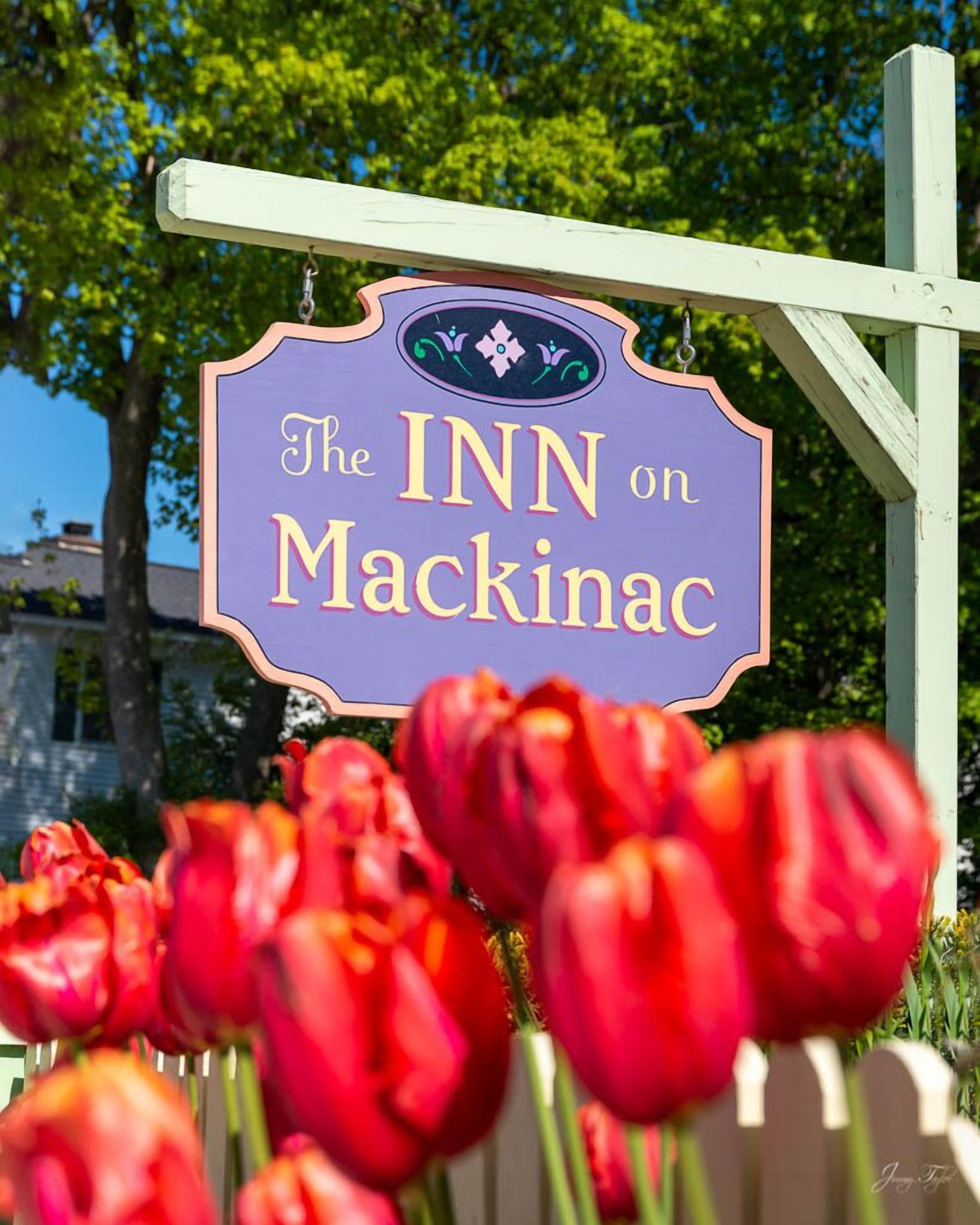 A sign for "The INN on Mackinac" with a decorative border and floral design.