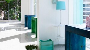 Ein modernes Interieur mit einem großen Fenster, einem Deckenventilator und einem kleinen Tisch mit einer Lampe.