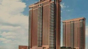 Un edificio de gran altura con varios pisos, que presenta un diseño arquitectónico moderno con líneas verticales y una entrada destacada en la base.