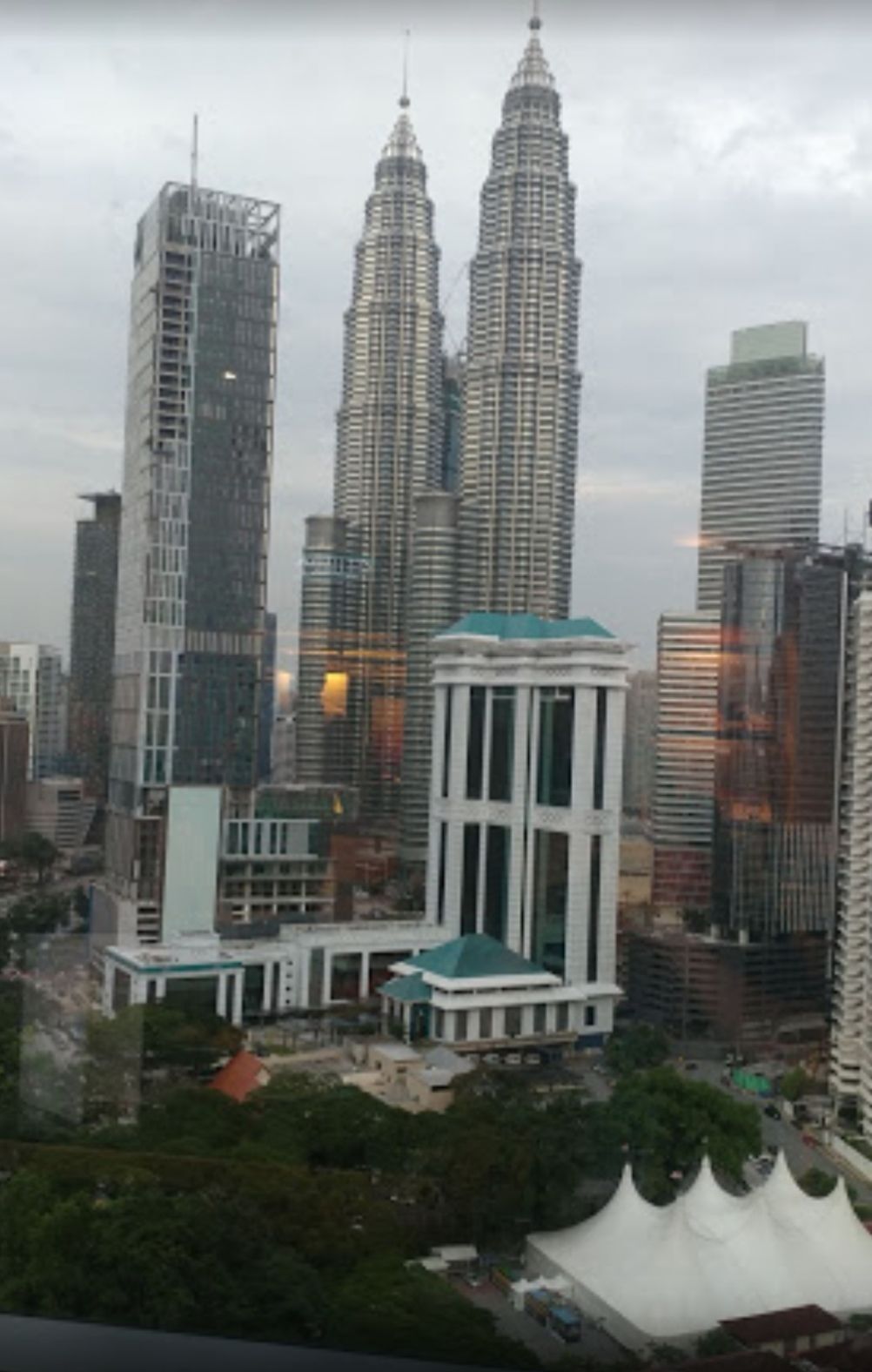 Une vue urbaine mettant en scène deux gratte-ciel imposants, dont l’un est doté d’un toit végétalisé original et l’autre, d’une flèche.