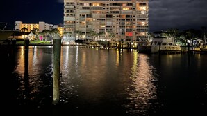 A multi-story hotel with balconies, a marina, and a body of water reflecting the building. - Hutchinson Island North Beach/Lagoon Access - First Floor Unit (Fort Pierce)