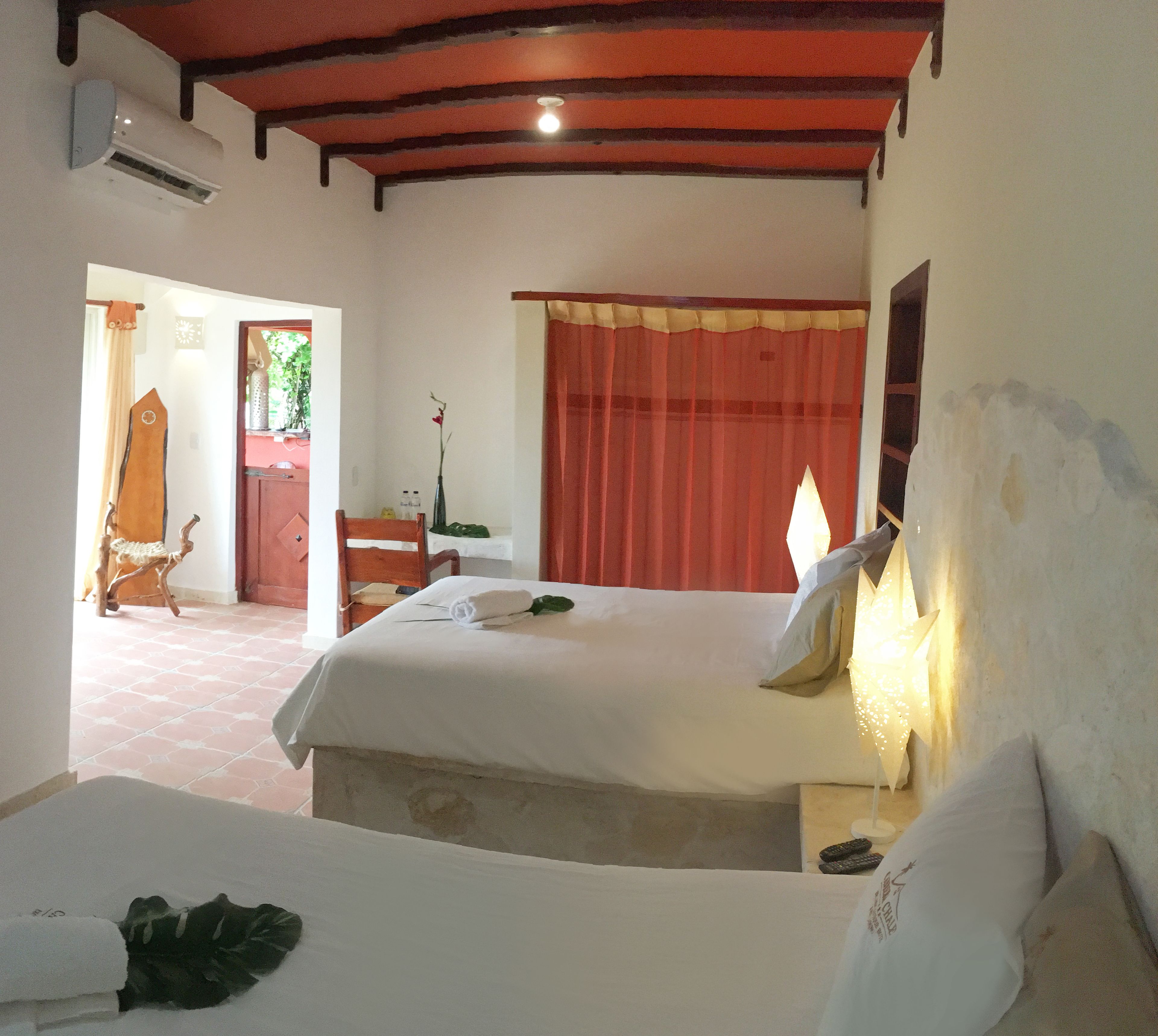 Una habitación de hotel con una cama grande, una silla, una mesa y una ventana con cortinas.