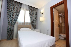 Quarto solteiro básico, vista parcial para o mar | Frigobar, escrivaninha, Wi-Fi de cortesia, roupa de cama