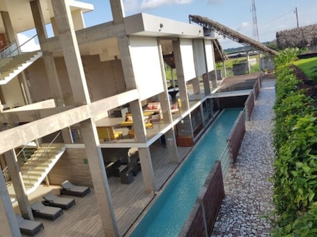 Una piscina al aire libre, sillones reclinables de piscina