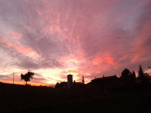 A sunset over a town with a prominent tower and residential buildings.