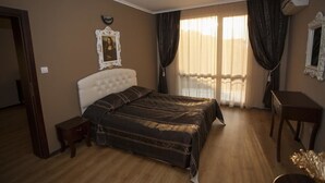 A bedroom with a large bed, a bedside table, a small cabinet, a mirror, and a window with curtains. - Red Hotel - Lozenetz (Tsarevo)