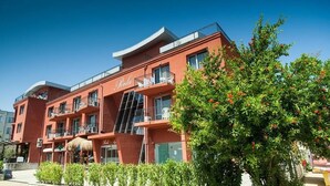 A red building with balconies and a sign that reads "Perla." - Red Hotel - Lozenetz (Tsarevo)