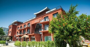 Un edificio rojo con balcones y un letrero que dice "Perla".