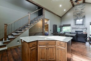 Enjoy cooking in this well-appointed kitchen with a large island and stone fireplace.