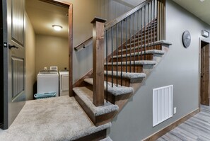 Staircase leads to a cozy area with a door and laundry facilities.