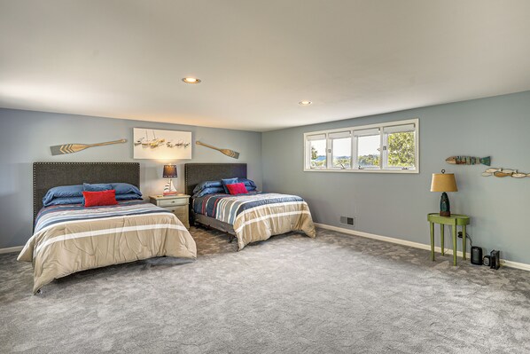 Een slaapkamer met twee bedden, een raam en een wand met decoratieve objecten.