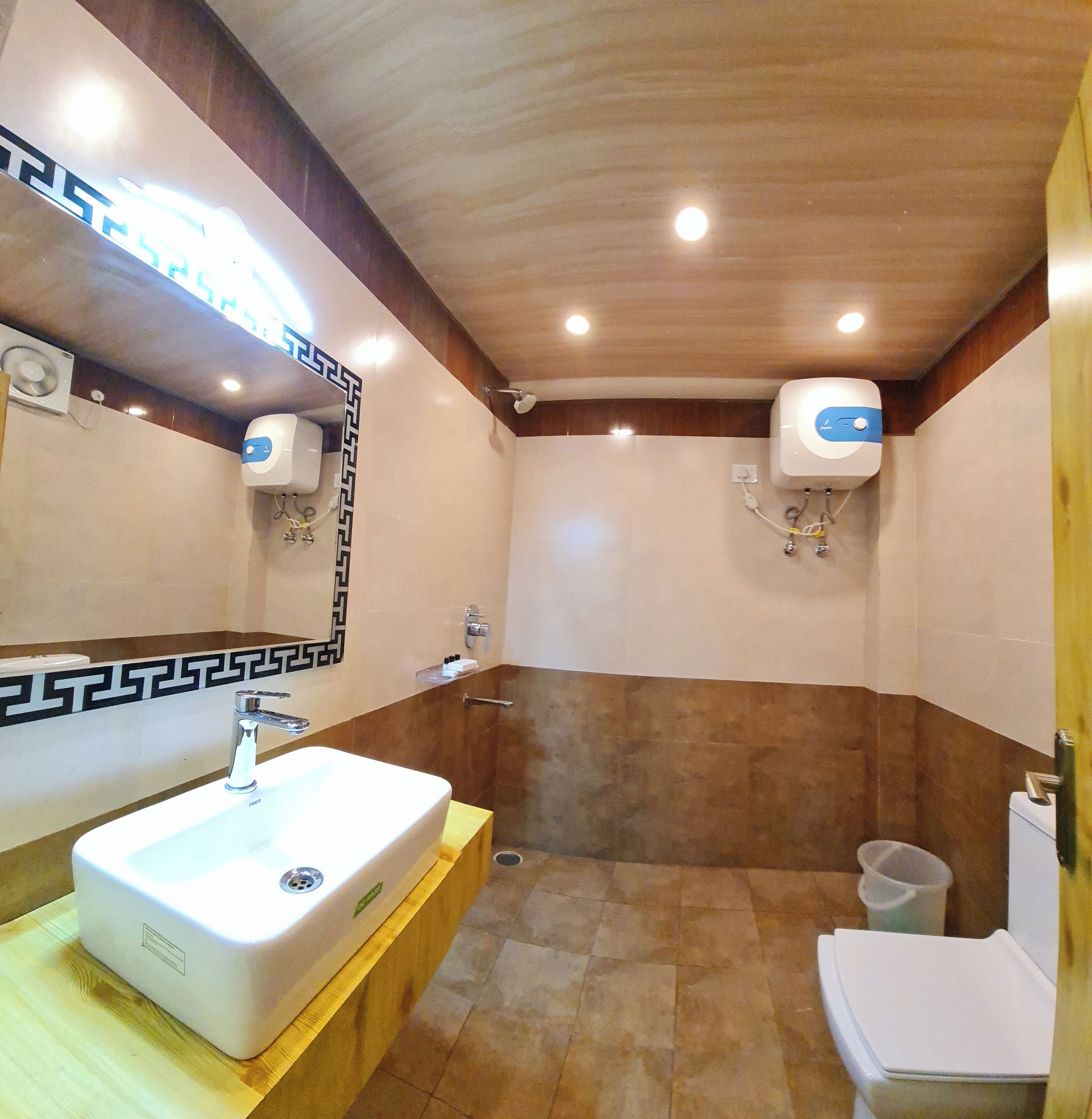A bathroom with a white sink, mirror, and two wall-mounted air dryers.