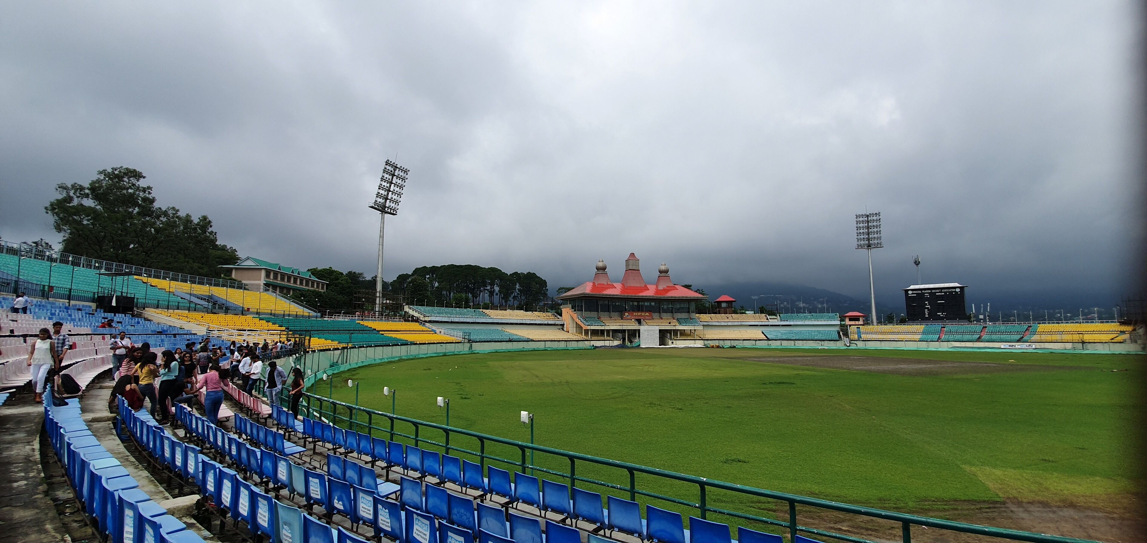 A stadium with tiered seating, a scoreboard, and floodlights.
