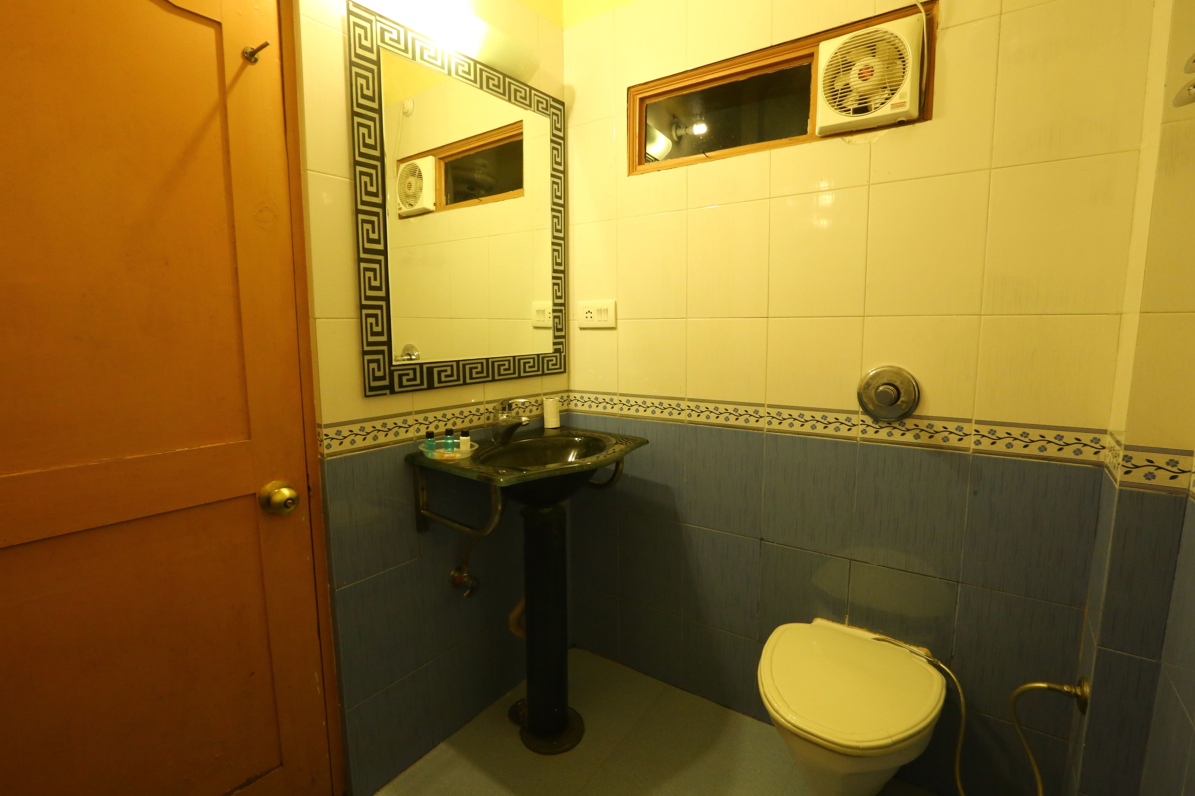 A bathroom with a sink, toilet, and a mirror.