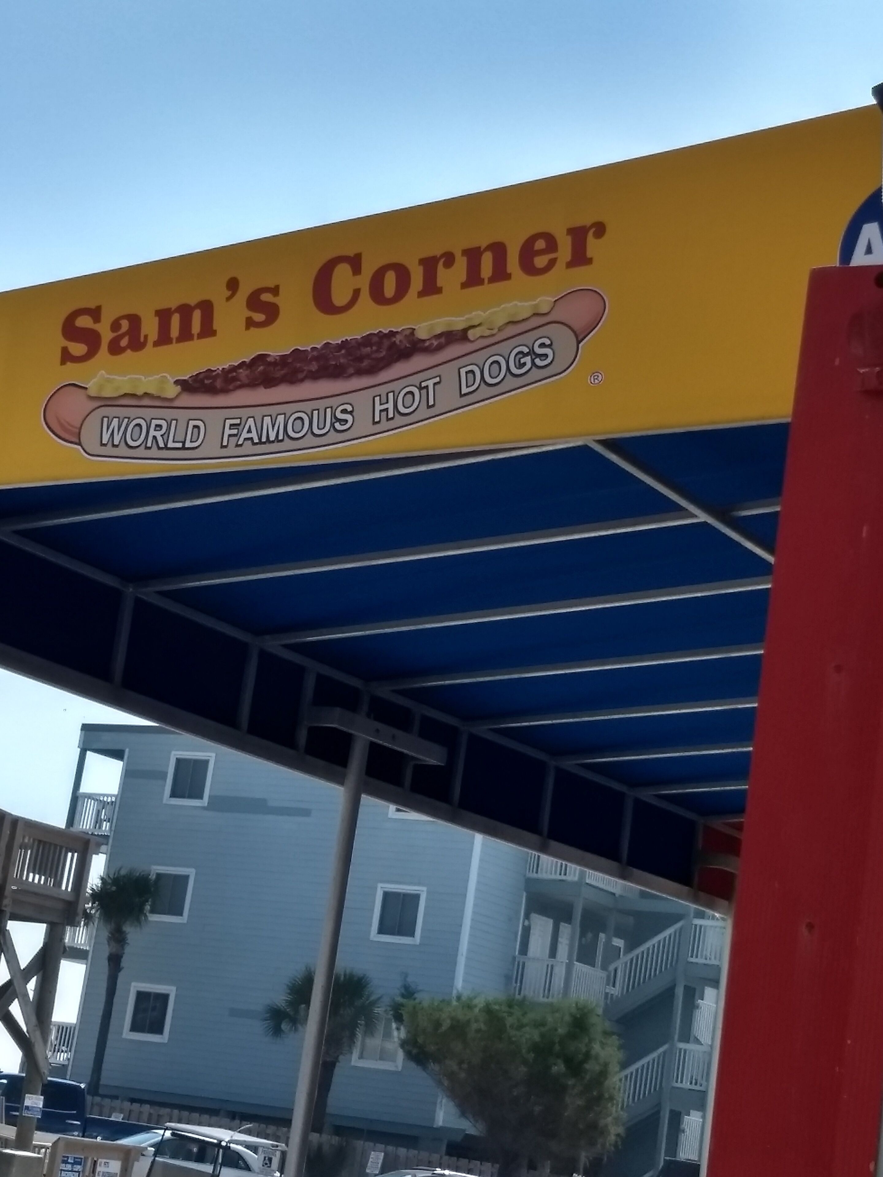 A building with a sign that reads "Sam's Corner World Famous Hot Dogs".