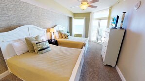 A bedroom with two beds, a nightstand, a dresser, and a ceiling fan. - Cozy Oceanfront Retreat, Steps from the Beach | OB 602 (Myrtle Beach)