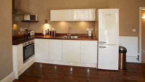 A modern kitchen with white cabinets, a stainless steel sink, and a built-in oven. - Host & Stay | Havelock Place Apartment (Whitby)