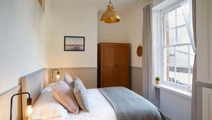 A bedroom with a bed, bedside lamp, window, and a view of the outside. - Host & Stay | Havelock Place Apartment (Whitby)
