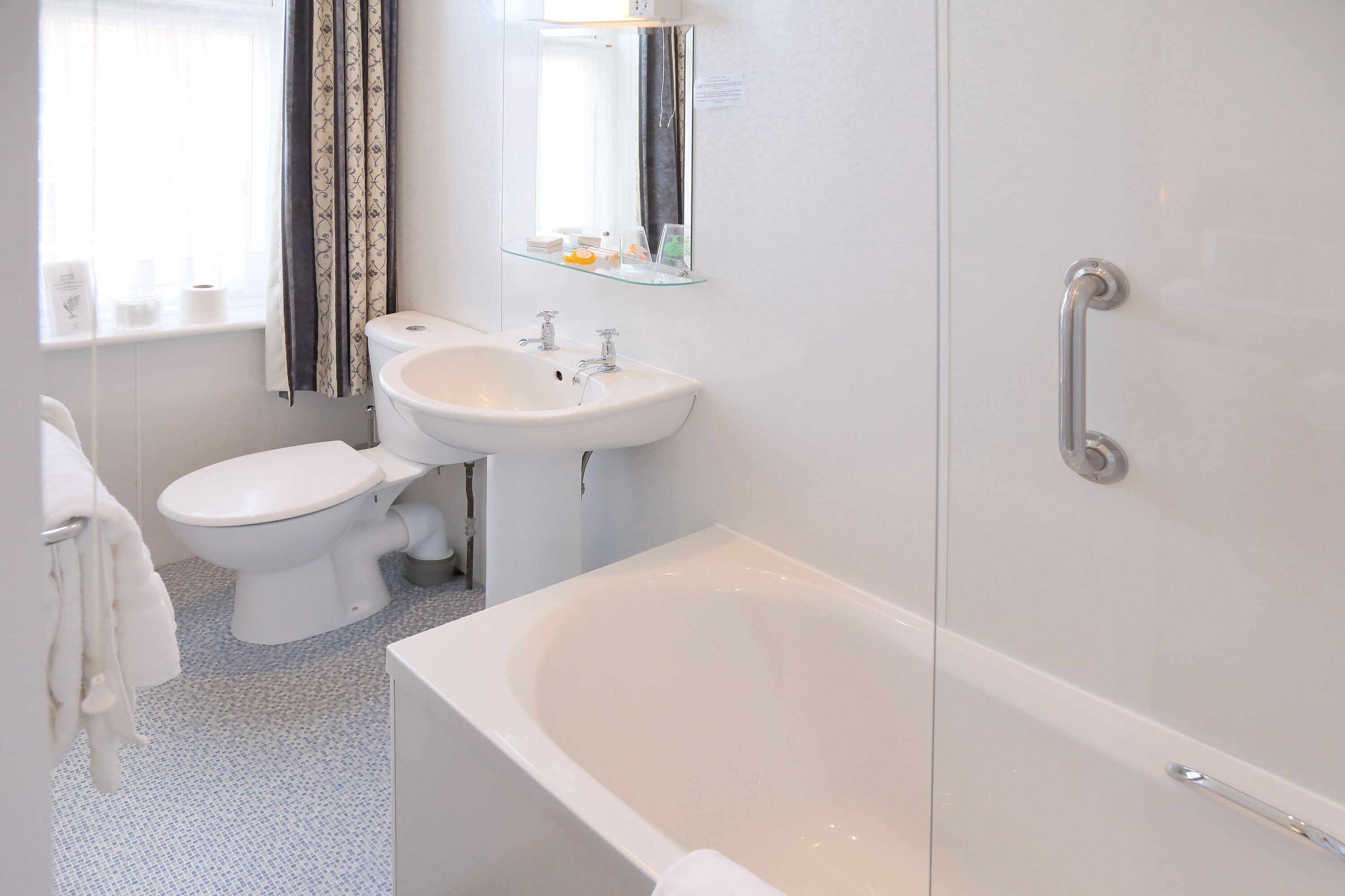 A modern bathroom with a white sink, toilet, and bathtub.