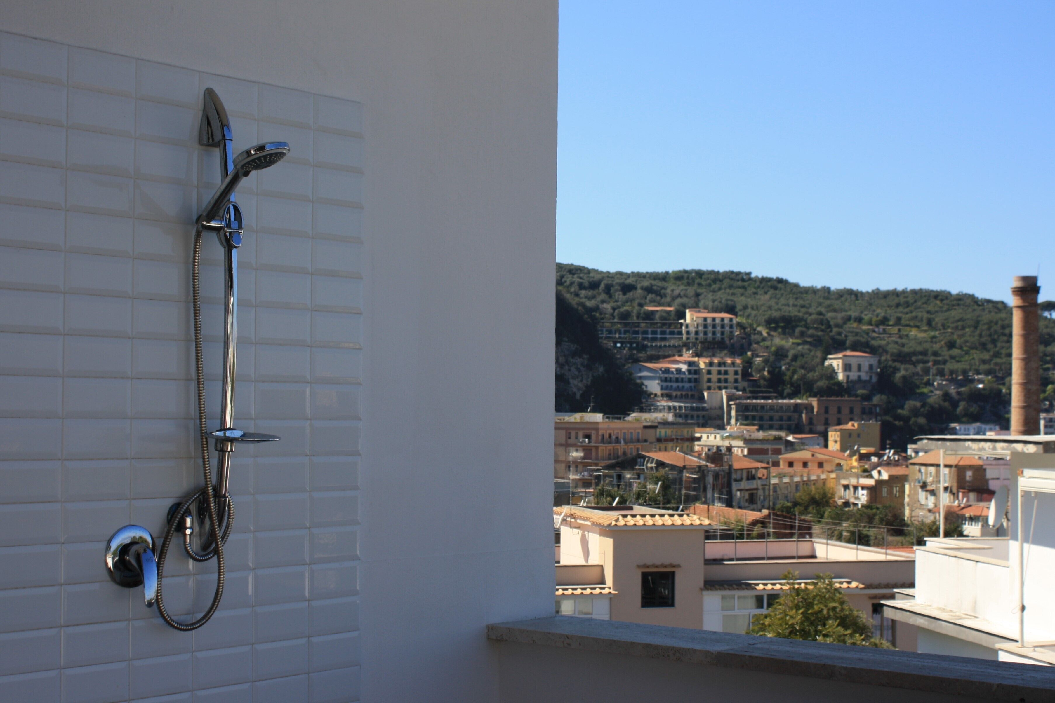 Ein Badezimmer mit Dusche und Blick auf die Stadt.