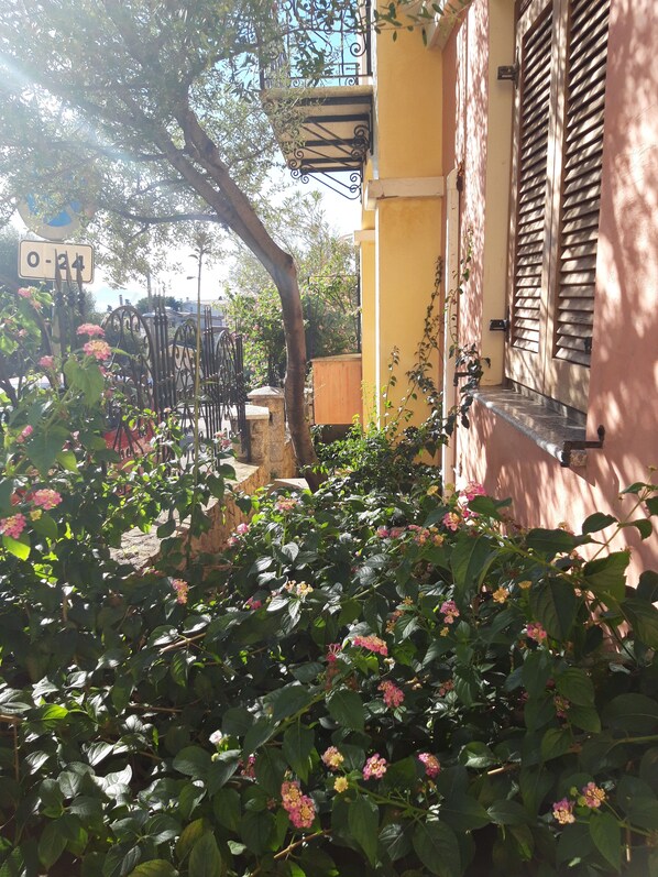A yellow building with a window and a door, surrounded by greenery and flowers. - ideal location a stone's throw from the sea and a few minutes walk from the cent (Santa Maria Navarrese)