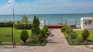 A paved pathway leading to a gate with a view of the sea.