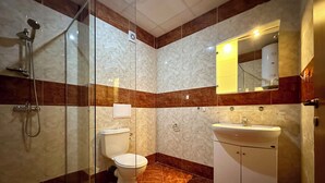A bathroom with a glass-enclosed shower, a toilet, and a sink with a mirror above it. - MENADA * Privilege Fort Beach * Cosy studio  (Elenite)