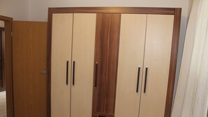 A wardrobe with two doors and a central panel, featuring a wooden frame and a beige interior. - Apartman Gracijela Poreč (Parenzo)